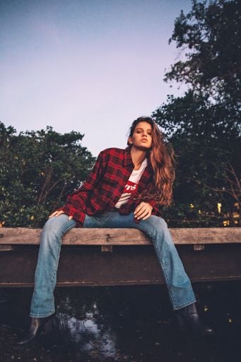 Young Woman Sitting in the Middle of an Asphalt Road · Free Stock Photo